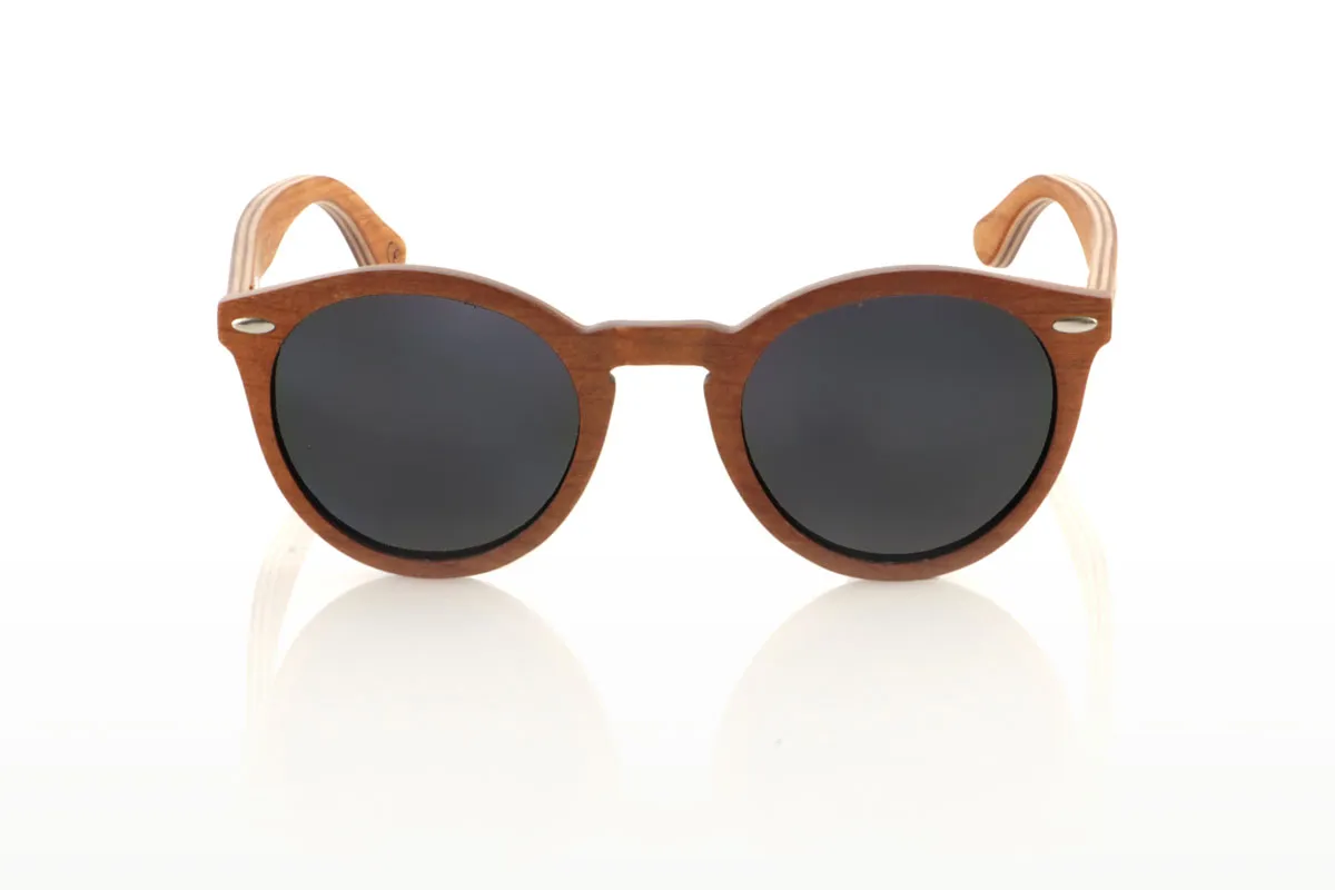 Gafas de Madera Natural de Cherry LINDA. Las gafas de sol de madera LINDA se presentan con una silueta redondeada y elegante, destacando por su montura en madera de cerezo laminada a contraveta, lo que no solo garantiza durabilidad sino también un estilo único gracias a su hermoso veteado. Los pines metálicos plateados en el frontal añaden un toque de distinción, equilibrando la calidez de la madera con un brillo sutil. Con unas medidas más ajustadas de 140x49 y un calibre de 48, estas gafas ofrecen un ajuste cómodo y un estilo versátil, perfecto para quienes buscan un complemento sofisticado y atemporal. Venta al Por Mayor y Detalle | Root Sunglasses® 
